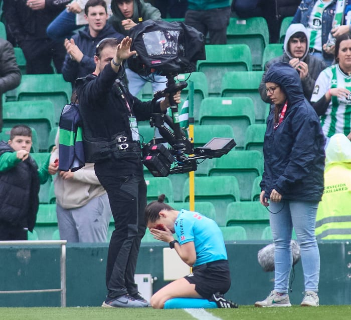 Assistant referee Guadalupe Porras Ayuso pictured (center) with blood on her face after colliding with a camera during a La Liga game between Real Betis and Athletic Bilbao in February 2024